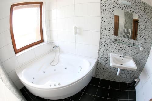 SládkovičovoGrand hotel/pension的白色的浴室设有浴缸和水槽。