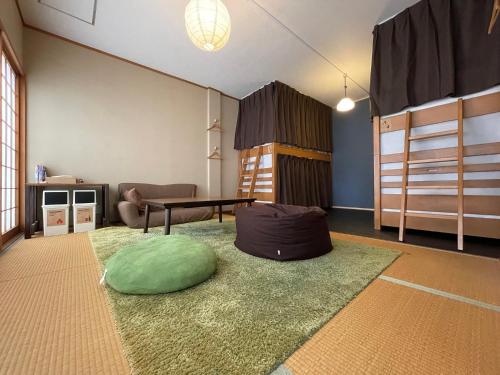京都Suzuki Guesthouse的客厅,楼下设有带绿色枕头的房间