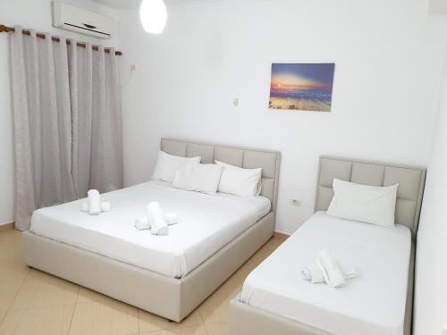 卡萨米尔Soare的配有白色墙壁的小客房内的两张床