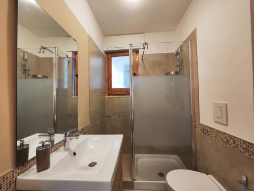 卡斯特拉巴特滨海Collins Apartments的一间带水槽、淋浴和卫生间的浴室