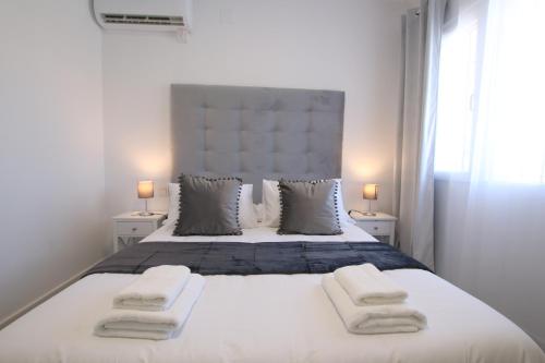 阿尔豪林德拉托里TESS Villa Paz的卧室配有带毛巾的大型白色床