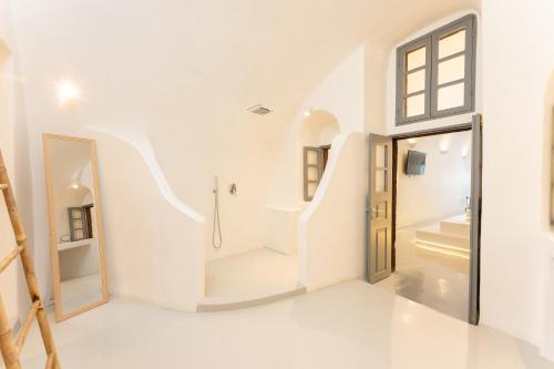 易莫洛林Cilon Suites Santorini的白色的浴室设有通往淋浴的楼梯