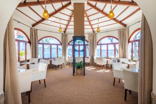 帕格拉卡拉福内尔斯酒店的一间设有白色桌椅和窗户的用餐室