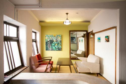 北九州Mojiko Guesthouse PORTO的客厅配有椅子和桌子