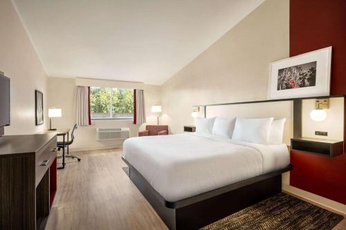 艾伦镇白厅/艾伦镇华美达酒店的配有一张床和一张书桌的酒店客房