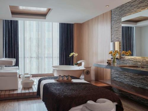 雅加达铂尔曼迦卡达中心公园酒店的带浴缸和浴室的酒店客房