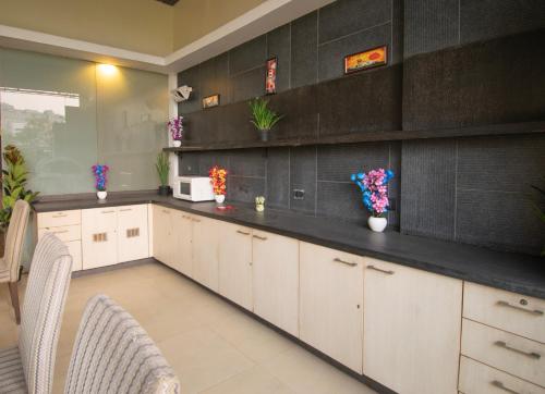 浦那Octave Koregaon Park的厨房配有白色橱柜和黑色墙壁