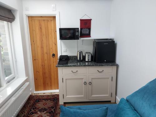 西卢港Peaceful Self-contained room near Looe的客房设有带微波炉的厨房。