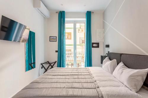 巴勒莫Palermo Central的一间卧室配有一张带蓝色窗帘的床和一扇窗户