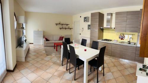 科内利亚诺Appartamento centro storico Conegliano的厨房以及带白色桌椅的起居室。