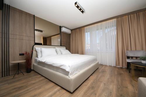 萨拉热窝Nest Apartments Sarajevo的卧室配有一张白色的大床和一张桌子