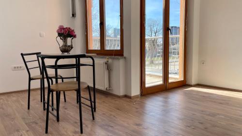 卢布尔雅那Apartments Katrca Bežigrad的一张桌子,上面有两把椅子和花瓶