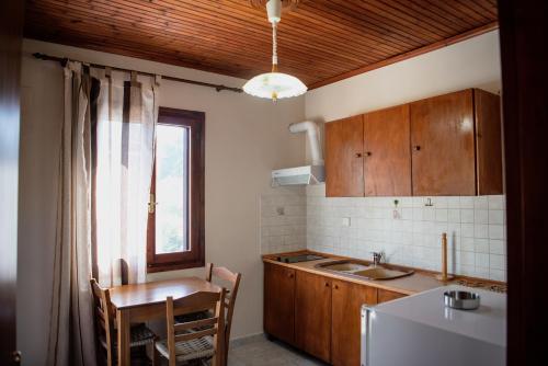 卡拉内拉Studio Sevasti的厨房配有桌子、水槽、桌子和窗户。