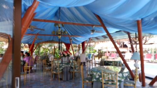 梭桃邑Jungle Moon Homestay จังเกิ้ลมูน โฮมสเตย์ บางเสร่的蓝色帐篷下的一组桌椅