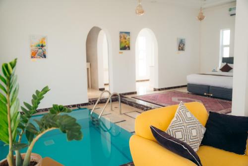 Al GhabbīJawharat Bidiyah Resort "JBR"的客厅配有黄色的沙发和桌子