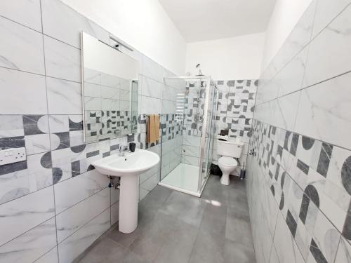 圣朱利安斯Rotas B&B的白色的浴室设有水槽和卫生间。