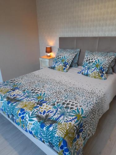 Saint-Jean-la-Poteriechambre d'hôtes Les Hortensias的一张带蓝色和白色棉被和枕头的床