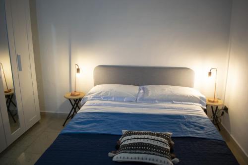 都灵Mimosa House的一间卧室配有一张床,两台桌子上放着两盏灯
