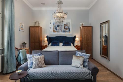 萨格勒布三七公寓的一间卧室配有一张床、一张沙发和一个吊灯。