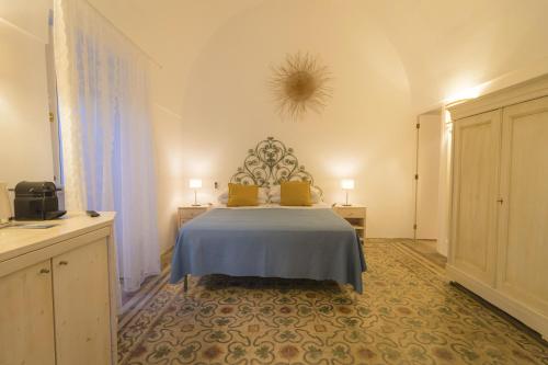 莱乌卡Villa Romasi的一间卧室配有一张带蓝色毯子的床