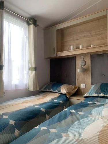 卡莱尔Grasmere Lodge Unit 31的一间卧室设有两张床和窗户。