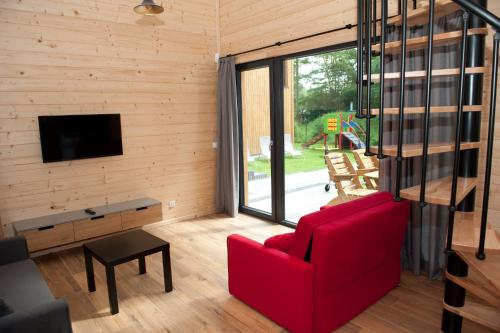 奥克宁卡Kapitanka Apartamenty的客厅配有红色沙发和电视
