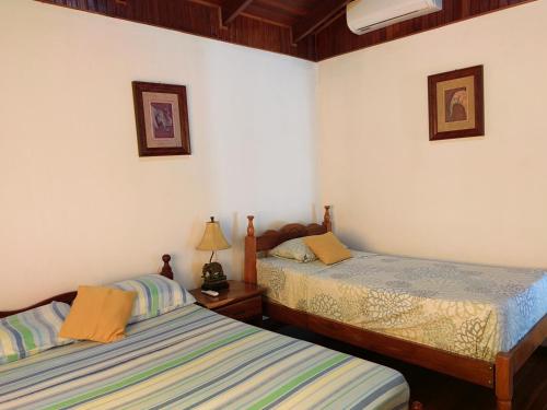 普拉亚埃尔莫萨Condominio Villa Hermosa的白色墙壁客房的两张床