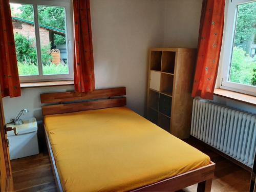 VisselhövedeFerienwohnung Bioland-Hof Wilkens的卧室配有床,位于带2个窗户的房间