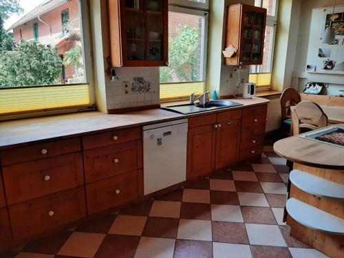 VisselhövedeFerienwohnung Bioland-Hof Wilkens的厨房配有木制橱柜、水槽和桌子