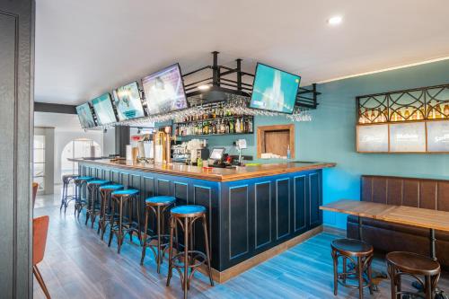 内尔哈Hotel Nerja Club Spa by Dorobe的餐厅里设有蓝色墙壁和凳子的酒吧