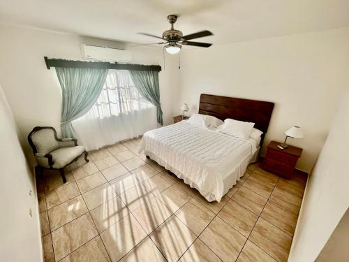 圣佩德罗苏拉Apartamentos Villas del Sol的卧室配有床、椅子和窗户。