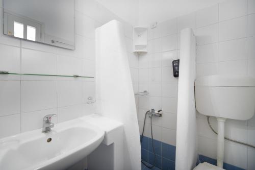 塞里福斯ISALOS ROOMS ON THE BEACH的白色的浴室设有水槽和卫生间。
