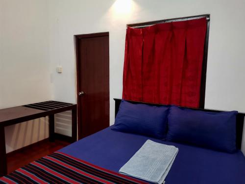 贾夫纳纳鲁尔假日旅馆的一间卧室配有一张床铺,上面有红色窗帘
