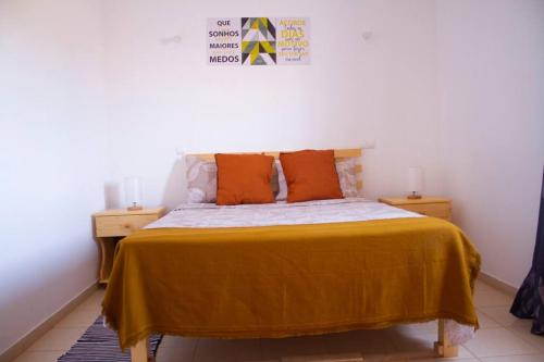 Calheta Do MaioCosy & Relax Yellow House 5mn walk from the beach!的一间卧室配有带橙色枕头的床