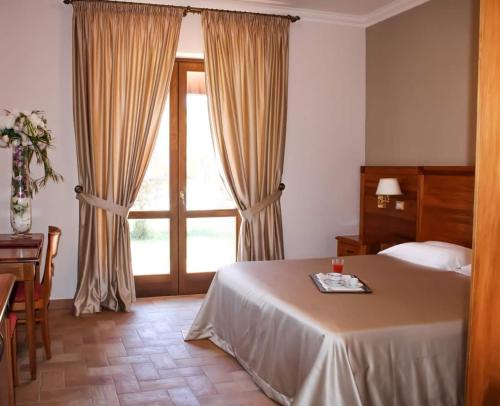 卢切拉维尼亚诺切利大酒店的一间卧室设有一张床和一个大窗户