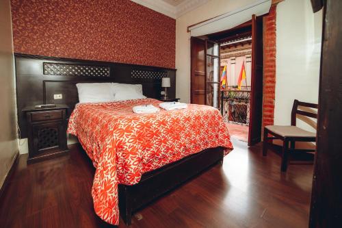 昆卡Gran Hotel París的一间卧室配有一张带红白毯子的床
