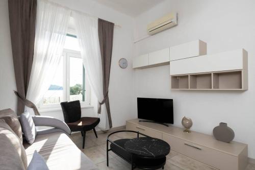 希贝尼克Apartment Val with sea view的带沙发和电视的白色客厅