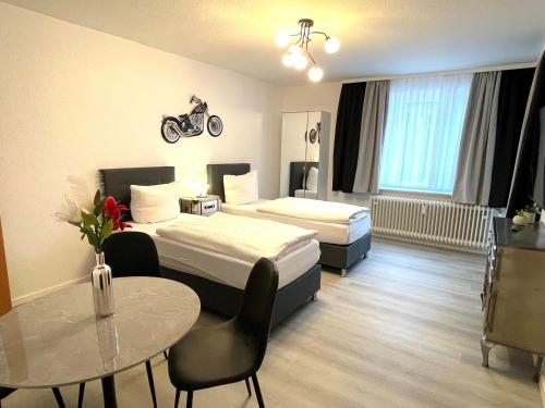 汉诺威Park-Residenz Isernhagen的酒店客房设有两张床和一张桌子。