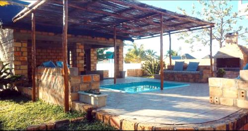 MiramarVenha Juntos Guest Homes的一个带游泳池和木制凉亭的庭院