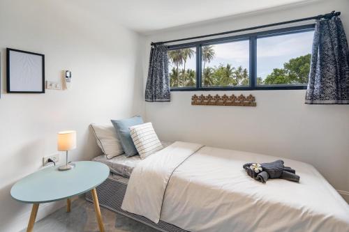 高兰Manao Pool Villa 12 - 5 Mins Walk To The Beach的一间卧室配有一张床、一张桌子和一个窗户。