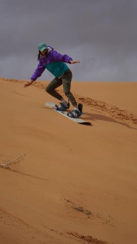 瓦迪拉姆Desert Jewel Camp的在沙漠中骑滑雪板的人