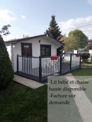 Faverges-de-la-TourChalet climatisé et chauffé a Faverges de la Tour的一座白色的小房子,带有栅栏和标志