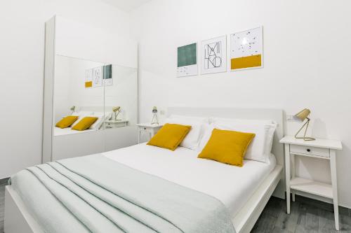米兰拉福尔泰扎公寓的白色卧室配有一张带黄色枕头的大床