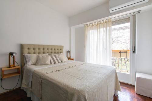 罗萨里奥Franca Estadías Temporarias的白色的卧室设有一张大床和一个窗户