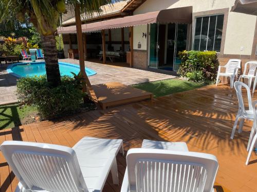 多明戈斯马丁斯Casa nas montanhas com piscina e vista panorâmica的一个带白色椅子的庭院和一个游泳池