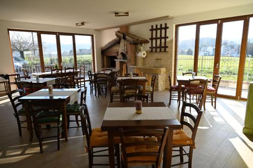 古比奥Agriturismo A Casa Mia Gubbio的餐厅设有桌椅和窗户。