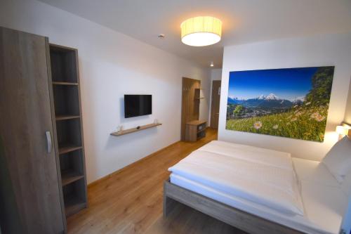 采德豪斯Sporthotel Zederhaus的卧室配有一张床,墙上挂有绘画作品
