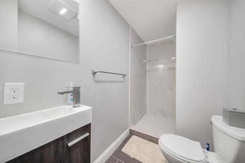 波士顿4BR1BTH South Boston Apt perfect for commutes的白色的浴室设有卫生间和淋浴。