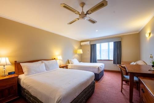 北克莱顿莫纳什捷威酒店的酒店客房配有两张床和一张书桌