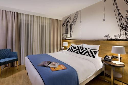 汉堡汉堡米歇尔馨乐庭服务公寓公寓式酒店的一间卧室配有一张大床和一张蓝色椅子